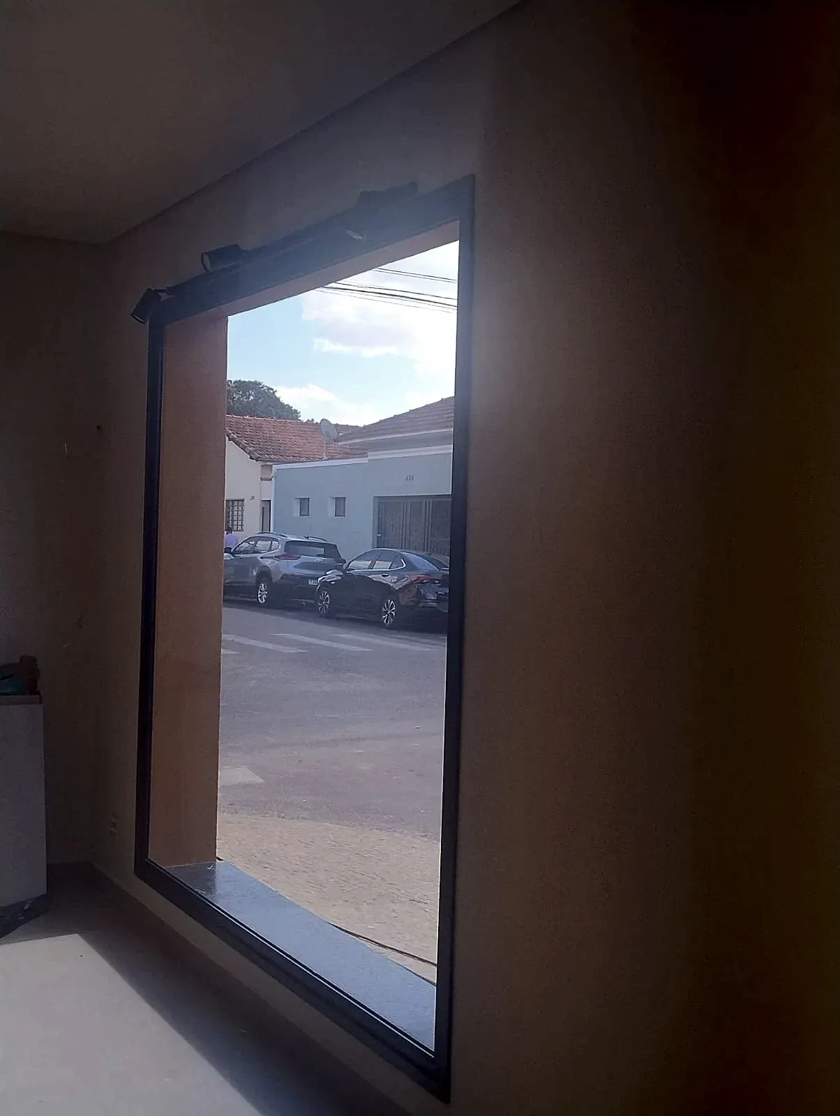 Vidro fixo em esquadria de alumínio visto de dentro da loja