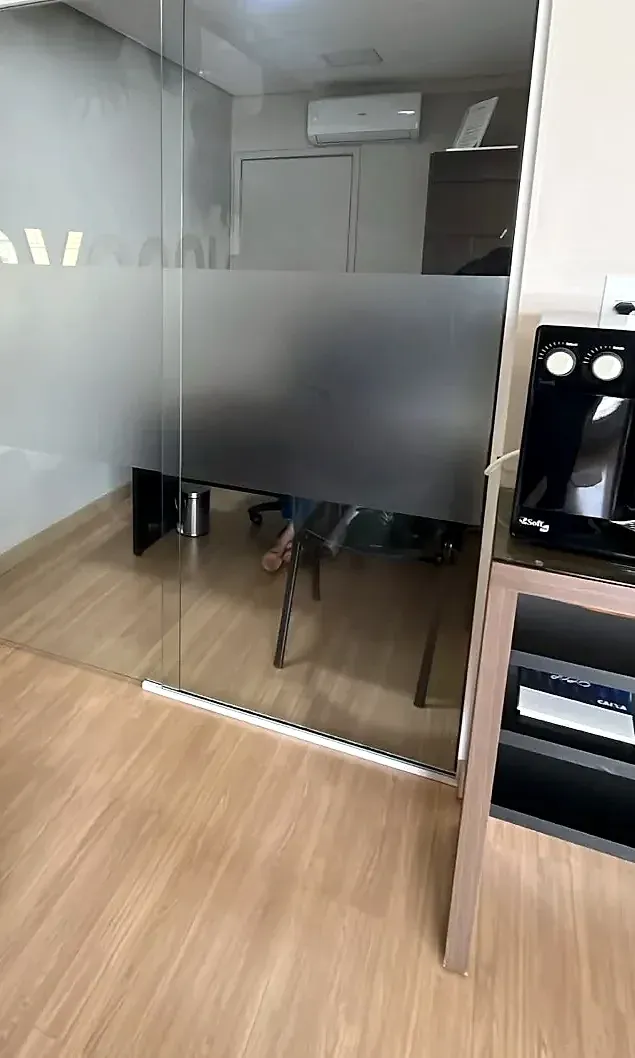 Porta de correr em vidro temperado com faixa jateada em sala de escritório